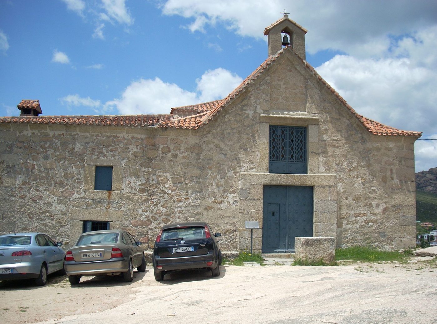 Reparación de tejados en Manzanares el Real | reparaciondetejados.madrid Fotografía de Manzanares el Real, en la Sierra de Madrid. Servicio local de reparación y limpieza de tejados y canalones — reparaciondetejados.madrid, zona de pinar, donde es habitual la limpieza de canalones obstruidos por hojas y acículas.